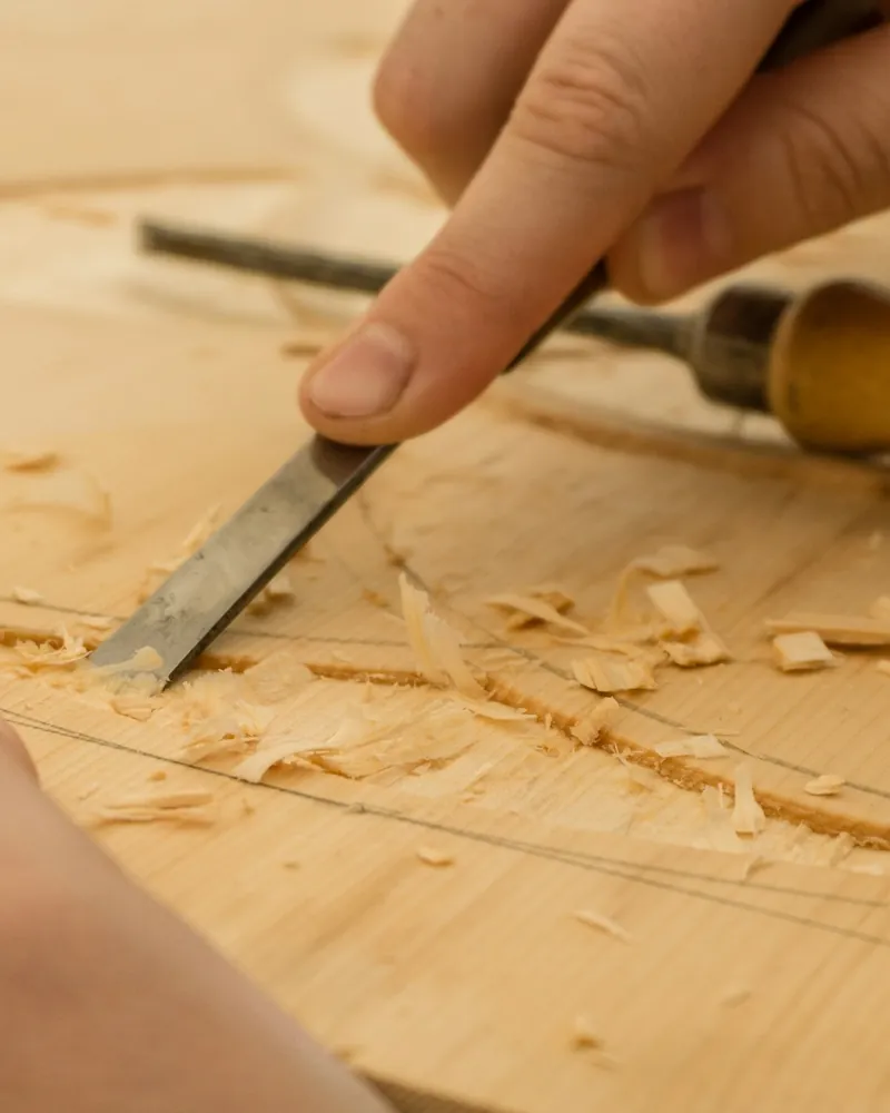Formón de carpintería cortando una entalladura en una pieza de madera sobre el banco